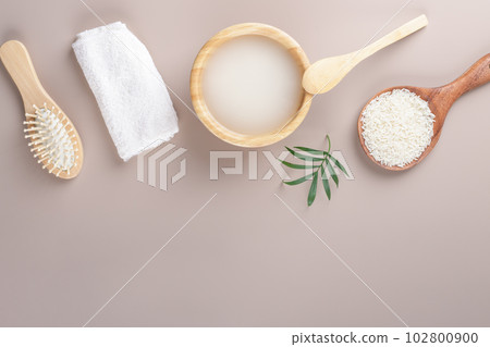 Homemade cosmetic rice water with ingredients and beauty kit on beige background, top view copy space, home spa flat lay 102800900