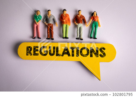 Regulations Concept. Yellow speech bubble with text and miniature human figures on a white Regulations Concept. Yellow speech bubble with text and miniature human figures on a white 102801795