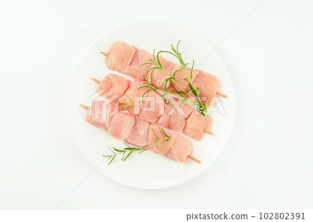 Skewers from raw chicken meat fillet on a white plate for supermarket on white background.Food for retail.Raw Chicken skewers breast Fillets.Ogranic food,healthy eating.Food concept.Top view. 102802391