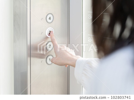 按電梯按鈕的婦女的手 按電梯按鈕的婦女的手 102803741