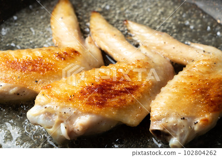Fry the chicken wings in a frying pan. (white wine grilled) 102804262