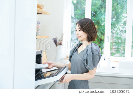 young woman using microwave young woman using microwave 102805071