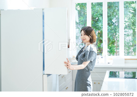 一個打開冰箱的年輕女子 102805072