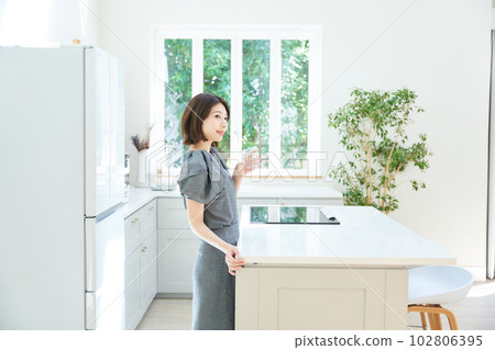 廚房裡拿著杯子的年輕女人 102806395