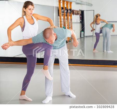 Woman practicing basic self defense movements with male partner Woman practicing basic self defense movements with male partner 102809428
