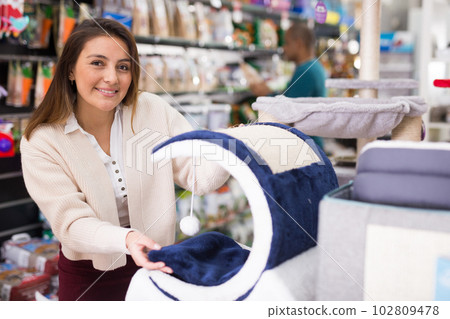 Female shopper chooses cat accessories at store Female shopper chooses cat accessories at store 102809478