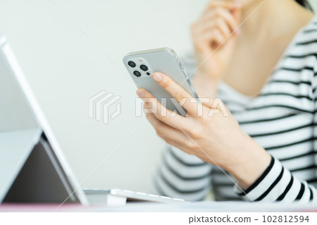 操作智能手機的年輕女性 操作智能手機的女性的手 102812594