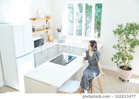 Young woman drinking coffee in dining kitchen Young woman drinking coffee in dining kitchen 102813477