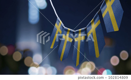 A garland of Sweden national flags on an abstract blurred background A garland of Sweden national flags on an abstract blurred background 102814809