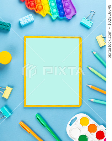 close-up of a paper notebook with blank sheets, a pen, a pencil and a paper clip on a blue background close-up of a paper notebook with blank sheets, a pen, a pencil and a paper clip on a blue background 102816649