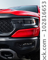 Red car headlights. Exterior detail. Close up detail on one of the LED headlights modern car. 102816653