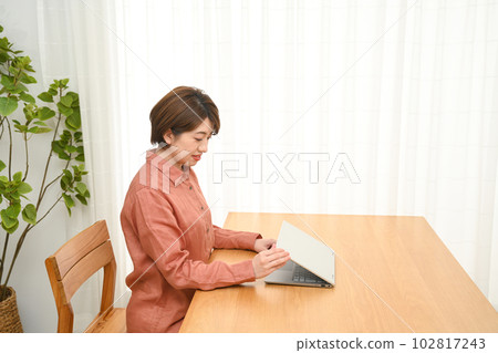 A woman who opens (closes) the laptop lid on the desk A woman who opens (closes) the laptop lid on the desk 102817243