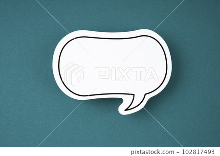 The White speech bubble shaped post it note on green background with copy space. 102817493