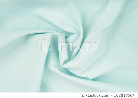 Delicate background of light blue soft plush fleece with embossed folds and waves. A modern backdrop for decorating. 102817504