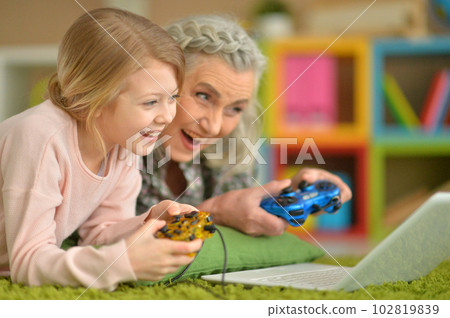 granny with her granddaughter playing computer game granny with her granddaughter playing computer game 102819839