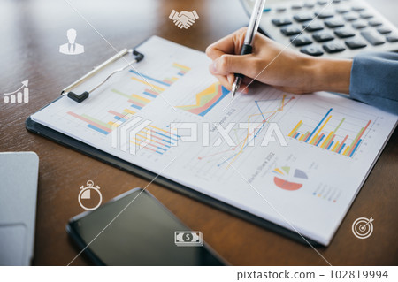 Business woman writing marketing note on paper charts graphs, Business financial and accounting concept, young female freelance financial working summary data outside at cafe coffee shop 102819994