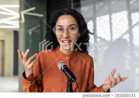 Webcam view, pov successful hispanic woman talking video call with friends working in office at workplace, businesswoman with professional microphone recording training business course. 102820131