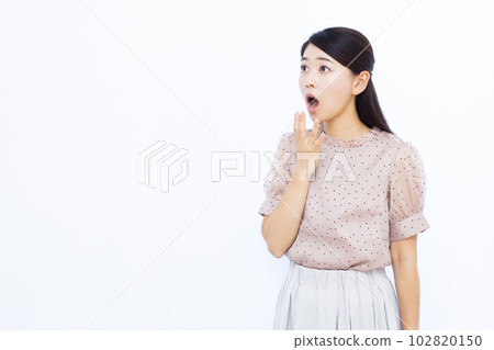 A woman in her thirties who is surprised in front of a white background 102820150
