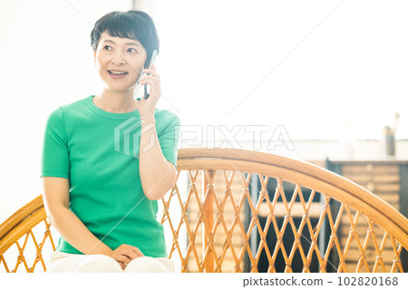 Middle woman making a phone call in the living room Middle woman making a phone call in the living room 102820168