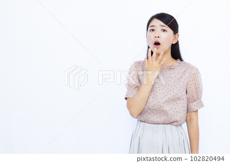 A woman in her thirties who is surprised in front of a white background A woman in her thirties who is surprised in front of a white background 102820494