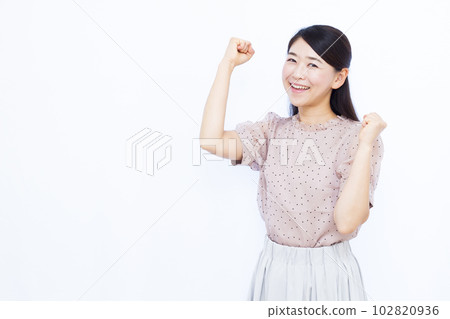 A woman in her thirties doing a guts pose in front of a white background A woman in her thirties doing a guts pose in front of a white background 102820936