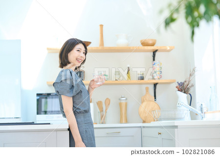 Young woman with a cup in the kitchen Young woman with a cup in the kitchen 102821086