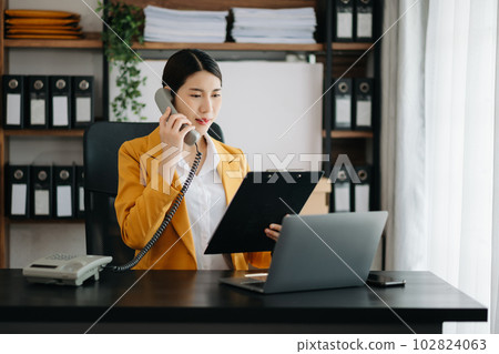 Asian business woman have the joy of talking on the smartphone, tablet and laptopon the modern office . Asian business woman have the joy of talking on the smartphone, tablet and laptopon the modern office . 102824063