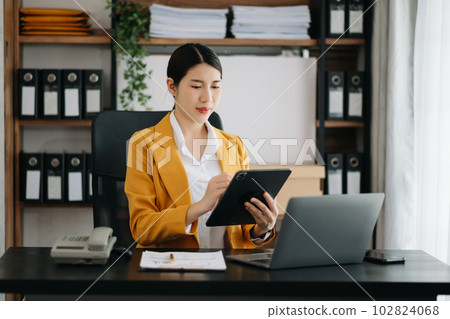 Business woman using tablet and laptop for doing math finance on an office desk, tax, report, accounting, statistics, and analytical research concept in office. Business woman using tablet and laptop for doing math finance on an office desk, tax, report, accounting, statistics, and analytical research concept in office. 102824068
