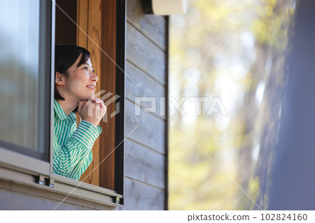 A young lady looking out of the window 102824160