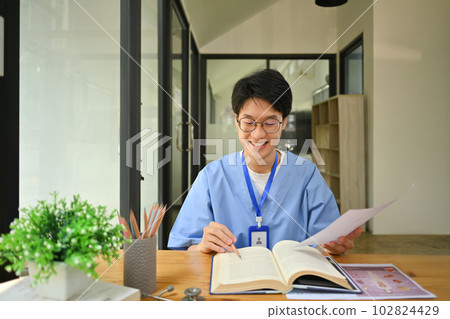 Medical student reading books, preparing for university exams in library. Medical internship concept 102824429