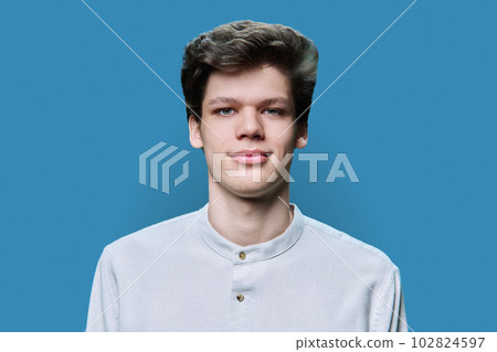 Headshot portrait of young male on blue background Headshot portrait of young male on blue background 102824597