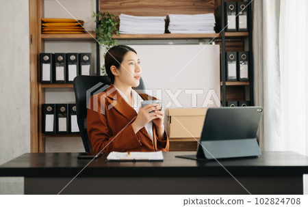 Business woman using tablet and laptop for doing math finance on an office desk, tax, report, accounting, statistics, and analytical research concept in office. Business woman using tablet and laptop for doing math finance on an office desk, tax, report, accounting, statistics, and analytical research concept in office. 102824708