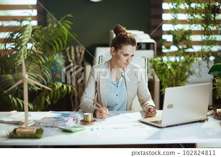 business woman in light business suit in green office 102824811