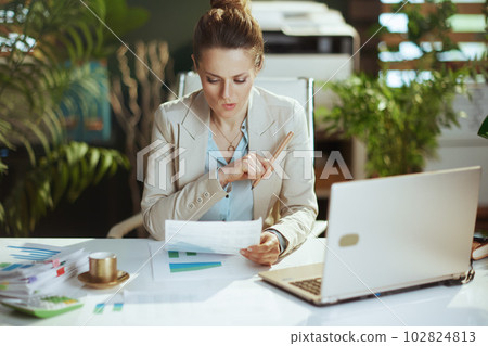 woman employee in light business suit in green office 102824813