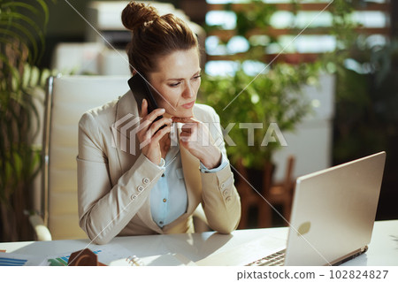 business owner woman in green office talking on phone 102824827