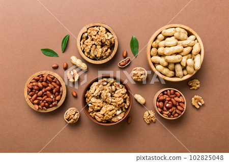 Walnut kernel halves, in a wooden bowl. Close-up, from above on colored background. Healthy eating Walnut concept. Super foods with copy space Walnut kernel halves, in a wooden bowl. Close-up, from above on colored background. Healthy eating Walnut concept. Super foods with copy space 102825048