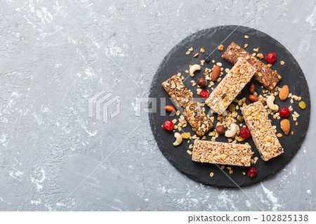 Various granola bars on table background. Cereal granola bars. Superfood breakfast bars with oats, nuts and berries, close up. Superfood concept Various granola bars on table background. Cereal granola bars. Superfood breakfast bars with oats, nuts and berries, close up. Superfood concept 102825138