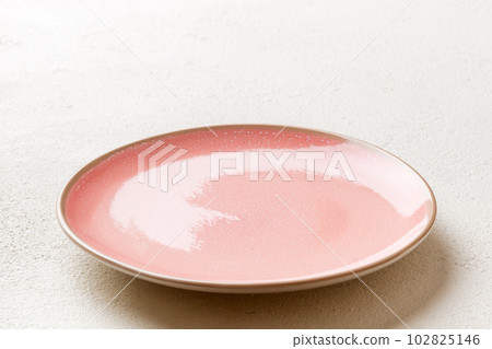 Perspective view of empty pink plate on cement background. Empty space for your design 102825146