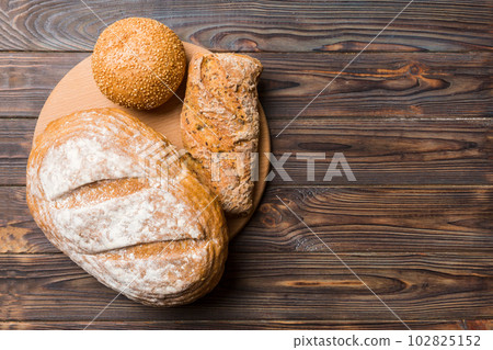 Freshly baked bread on cutting board against white wooden background. top view bread with copy space 102825152