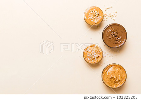 Glass jar with peanut butter on table background, top view space for text and close up Glass jar with peanut butter on table background, top view space for text and close up 102825205