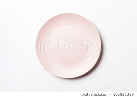 Top view of isolated of colored background empty round beige plate for food. Empty dish with space for your design 102825389