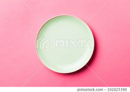 Top view of isolated of colored background empty round green plate for food. Empty dish with space for your design Top view of isolated of colored background empty round green plate for food. Empty dish with space for your design 102825390