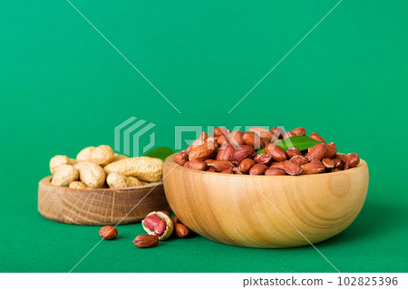 Fresh healthy peanuts in bowl on colored table background. Top view Healthy eating bertholletia concept. Super foods Fresh healthy peanuts in bowl on colored table background. Top view Healthy eating bertholletia concept. Super foods 102825396