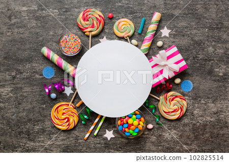Flat lay holiday composition. Paper blank, lollipop, birthday decorations on Colored background. Top view, copy space for text Flat lay holiday composition. Paper blank, lollipop, birthday decorations on Colored background. Top view, copy space for text 102825514