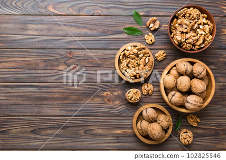 Walnut kernel halves, in a wooden bowl. Close-up, from above on colored background. Healthy eating Walnut concept. Super foods with copy space Walnut kernel halves, in a wooden bowl. Close-up, from above on colored background. Healthy eating Walnut concept. Super foods with copy space 102825546