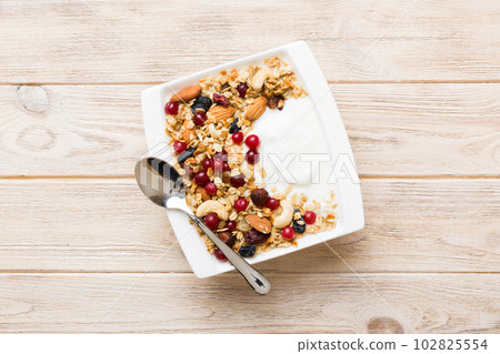 Healthy breakfast food with granola, yogurt, fruits and nuts. Dessert parfait with dried fruits for breakfast 102825554