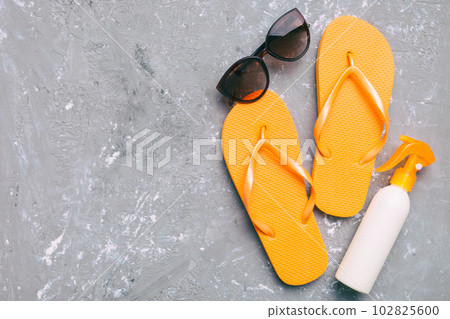 Summer travel concept. Flip flops, sunglasses and starfish on white. Top view on colored background 102825600