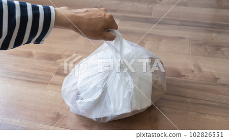 put trash in a plastic bag put trash in a plastic bag 102826551
