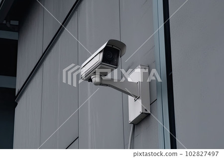 Security camera on modern building. CCTV on the wall in the city. Generative AI 102827497