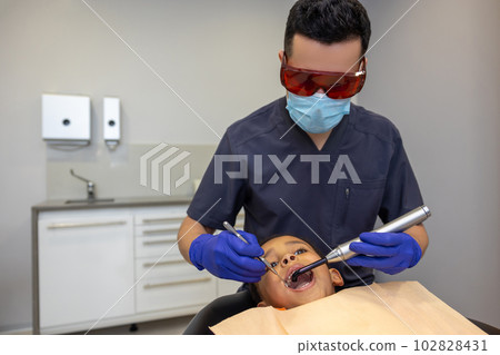 Doctor in eyeglasses treating boys teeth 102828431